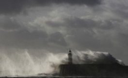 Waves crash against a lighthouse during storms that battered Britain and where a 14-year-old boy was swept away to sea, at Newhaven in South East England